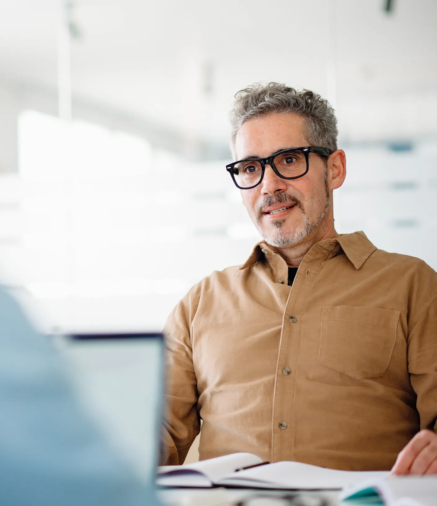 Mann mit beigem Hemd in einer Besprechung